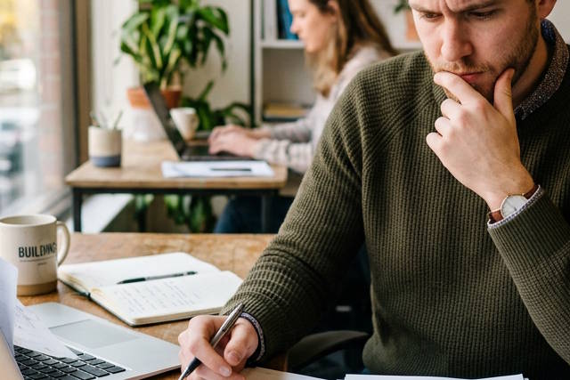 גבר חושב עם עט בידו